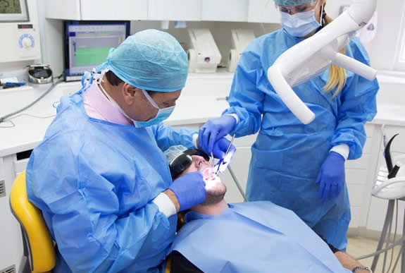 Dr. Mahesh patel performing dental implnt at queen's gate dental practice in london uk